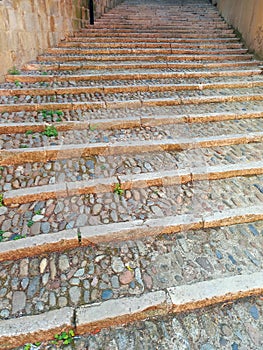 Perspective view of cobblestone and stone staircase. Pavement stone steps texture. Granite cobblestone floor. Architecture and