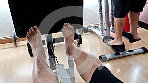 Perspective view of elderly physiotherapy patients performing leg press to strengthen weakened calf muscles as recovery