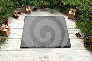 Perspective view. Empty black slate square plate on wooden christmas background. holiday dinner dish concept with new year decor