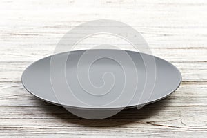 Perspective view. Empty Gray round plate on wooden background