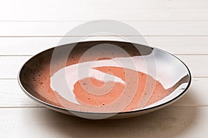 Perspective view of empty red plate on wooden background. Empty space for your design