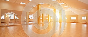 Perspective view of empty sunny yoga studio with wooden flooring
