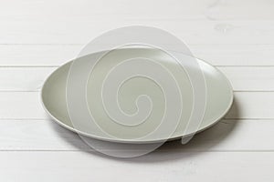 Perspective view. Empty white plate on wooden background