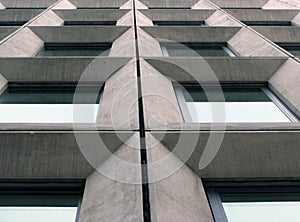 Perspective view of geometric angular concrete windows on the facade of a modernist 1960s brutalist style building