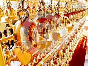 Perspective view group of small golden bells hang in Thai temple