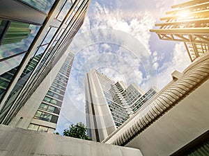 Perspective view high rise real estate of hotel apartment condo tower building with cloud blue sky and sun flare background