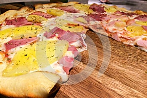 Perspective View of Hot Homemade Traditional Classic Italian Pizza Slice with Meting Cheese, Ham and Pineapple