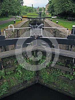 A perspective view of lock gates on the calder and hebble navigation canal at sowerby bridge in west yorkshire with town buildings