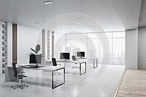 Perspective view of modern empty office interior with concrete and wooden floor, white walls and desks with computers, window with