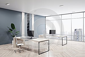 Perspective view of modern empty office interior with wooden floor, dark walls and desks with computers, window with city view and