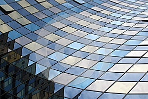 Perspective view of the modern glass building facade with reflections on the windows. Architectural pattern
