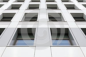 Perspective view of the modern gray building facade with windows. Architectural pattern