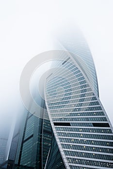 Perspective view of the modern skyscrapers outgoing to the foggy sky