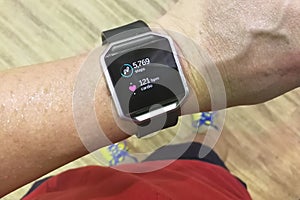 Perspective view person reading watch with steps and heart tracker during