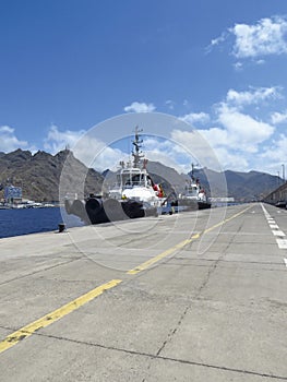 Perspective view of tug boat docked at port dock. Professional boat for port work. Large tugboat berth in the port. Nautical