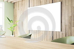 Perspective view of white blank poster on wooden wall in modern office meeting room interior with desk, plant and window, business