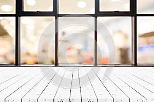 Perspective white wooden board empty table on top over blurred department store background, can be used mock up for display of