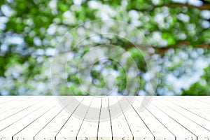 Perspective white wooden table on top over blur natural background, can be used mock up for montage products display or design la