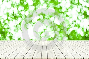 Perspective white wooden table on top over blur natural green bo
