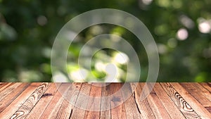 Perspective wood and bokeh light background. product display template. Wood table top on blur moving natural green leaf