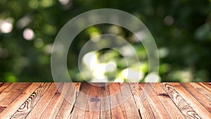 Perspective wood and bokeh light background. product display template. Wood table top on blur moving natural green leaf