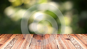 Perspective wood and bokeh light background. product display template. Wood table top on blur moving natural green leaf