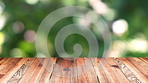 Perspective wood and bokeh light background. product display template. Wood table top on blur moving natural green leaf