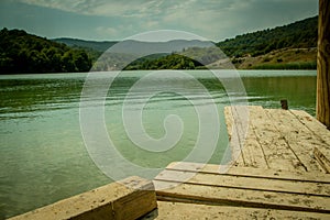 Perspective Wooden board empty table in front of nature background with mountain and lake.