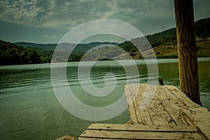 Perspective Wooden board empty table in front of nature background with mountain and lake.