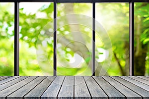 Perspective wooden board empty table on top over blurred natural background, can be used mock up for display of product or design