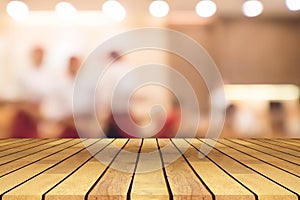 Perspective wooden table on top over blur coffee shop background