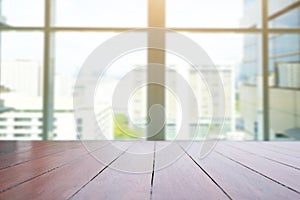 Perspective wooden table on top over blur modern building  background, can be used mock up for montage products display or design
