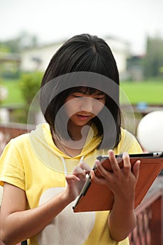 Pertty Asian young girl on tablet .