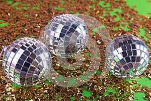 Perty shining mirror disco balls lay on golden sequins background