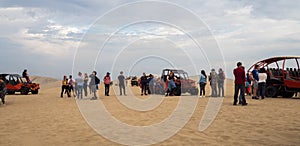 Panoramic of many tourists and buggies at Huacachina desert