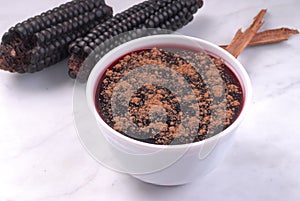 Peruvian dessert called mazamorra morada the main ingredient purple corn visible in the back