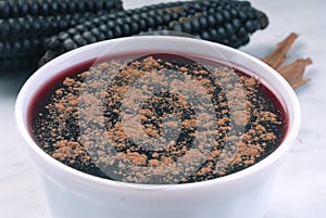 Peruvian dessert called mazamorra morada the main ingredient purple corn visible in the back