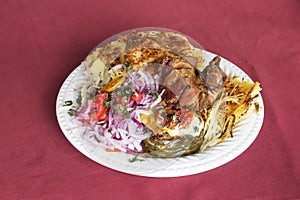 Peruvian Dish: Doble from Arequipa. Fried pig (Chicharron), smashed potatoes (pastel de papa), onion, tomatoes, spaghetti with c photo