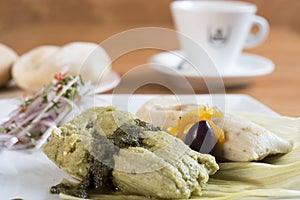 Peruvian food, tamales verdes. Fresh corn and coriander leaves are the basis of these delicious homemade green tamales. photo