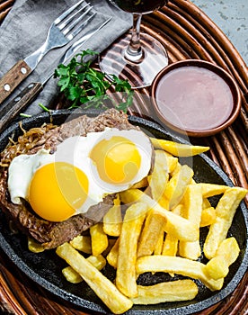 Peruvian Latin American food. Lomo a lo pobre. Beef whit fried potatoes french fry and eggs photo
