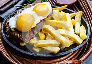 Peruvian Latin American food. Lomo a lo pobre. Beef whit fried potatoes french fry and eggs photo