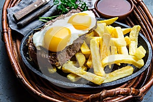 Peruvian Latin American food. Lomo a lo pobre. Beef whit fried potatoes french fry and eggs photo