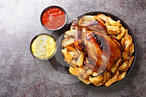 Peruvian Pollo a la Brasa chicken with fried potatoes and sauces close-up in a plate. horizontal top view photo