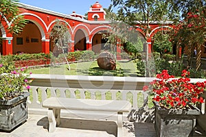 Peruvian styled vivid red colored buiding with flowering garden at the oasis town of Huacachina, Ica region, Peru photo