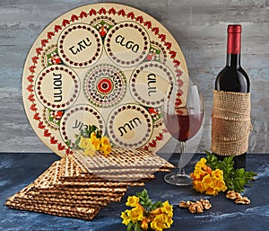 Pesach celebration concept - Jewish holiday Pesach. Background with yellow flowers with glass of wine, matzah and plate