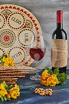Pesach celebration concept - Jewish holiday Pesach. Background with yellow flowers with glass of wine, matzah and plate