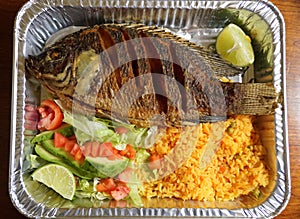Pescado Frito, a Mexican dish with fried tilapia, yellow rice and salad