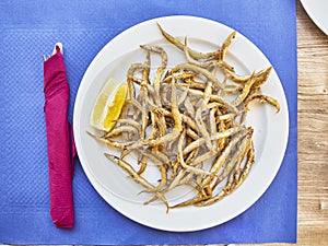 Pescaito frito, fried fish Andalusian style on a tavern table.