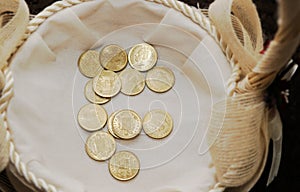 Pesetas, old Spanish coins used as earnest in a basket.