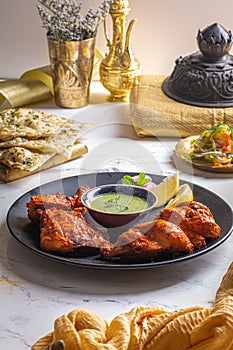Peshawari Chicken with chutney, raita, lime, salad and roti served in a dish isolated on dark background side view food photo